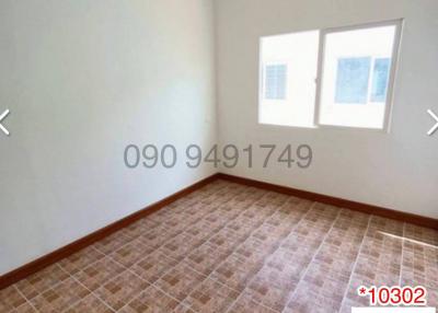 Spacious empty bedroom with two windows and tiled floor