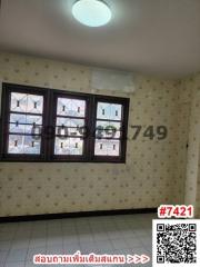 Spacious bedroom with three windows and patterned wallpaper