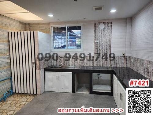 Modern kitchen interior with clean counter tops, ample cabinet space and natural light from window
