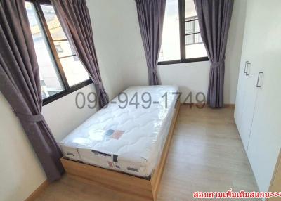 Minimalist bedroom with large windows and hardwood flooring