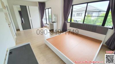 Spacious unfurnished bedroom with large window and wooden flooring in a residential home