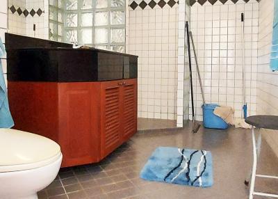 Spacious modern bathroom with tiled flooring and wooden vanity