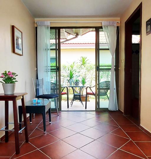 Cozy living room with terrace access showing tiled flooring and glass doors