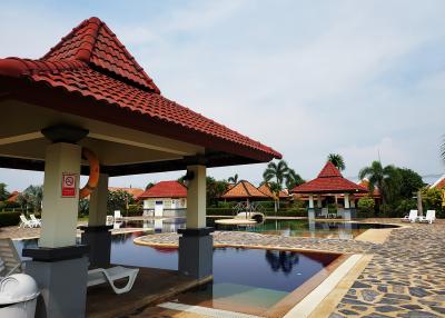 Communal swimming pool with patio and sun loungers in a residential complex