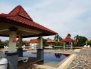 Communal swimming pool with patio and sun loungers in a residential complex