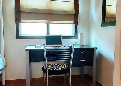 Home office with a desk, chair, and window with shades