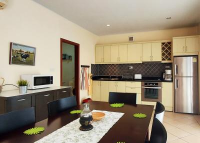 Modern kitchen with dining area, stainless steel appliances, and ample cabinetry