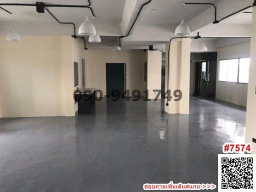 Spacious empty interior of a commercial building with industrial ceiling lights