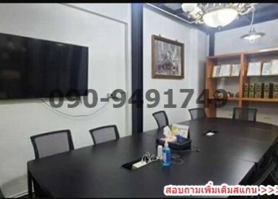 Spacious conference room with large table, chairs, and television