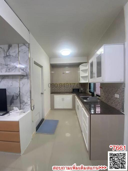 Modern kitchen with marble backsplash and stainless steel appliances in a well-lit space