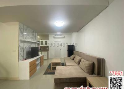 Compact living room with integrated kitchen space including modern furnishings and ample lighting