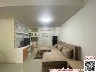 Compact living room with integrated kitchen space including modern furnishings and ample lighting