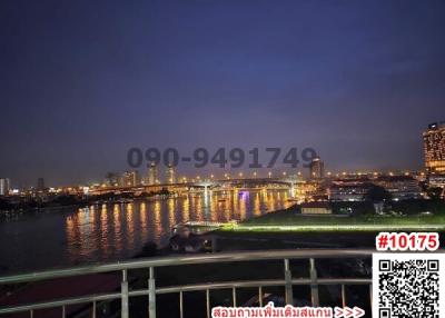 View from balcony overlooking river at dusk with city lights