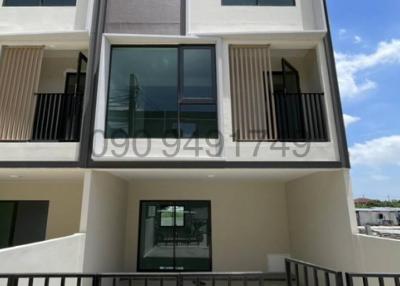 Modern three-story building facade with balconies and large windows