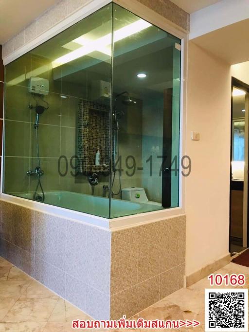 Modern bathroom with glass shower enclosure and beige tiles
