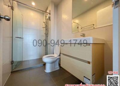 Modern bathroom interior with a glass shower cubicle, white basin, and toilet
