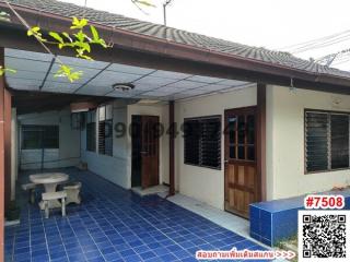 Exterior view of a residential building with blue tiled flooring and a sitting area