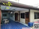 Exterior view of a residential building with blue tiled flooring and a sitting area