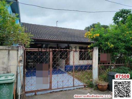 Front view of a house with a gated fence and tiled entrance