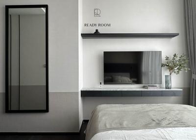 Modern bedroom interior with a large bed, mounted television, and minimalist decor