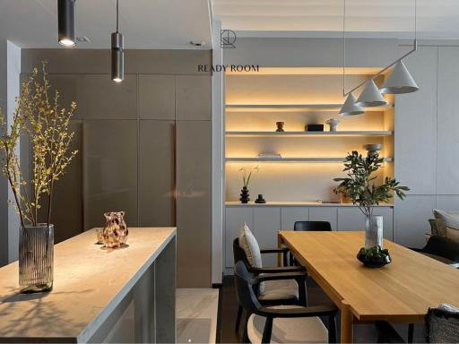Modern kitchen with dining area, pendant lighting, and built-in shelving