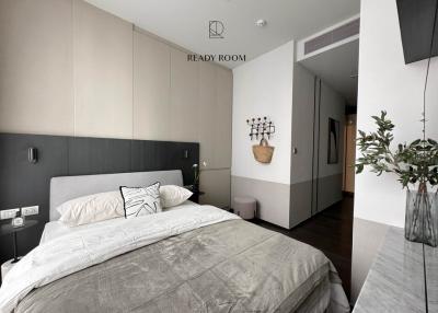 Modern bedroom with a neatly made bed, minimalistic decor, and a clean aesthetic