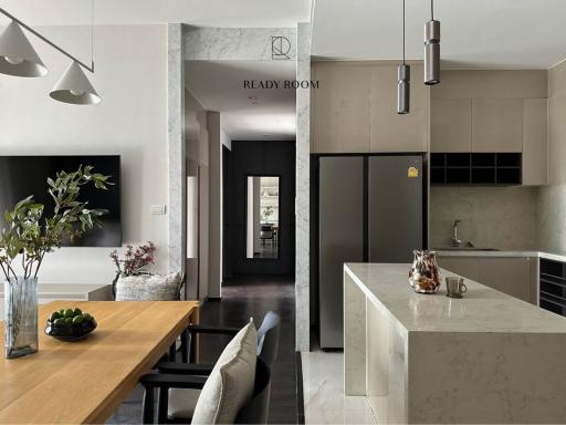 Modern kitchen with marble countertops and a view into the dining area