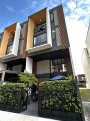 Modern multi-story residential building with balconies and gated entrance