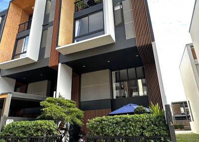 Modern multi-story residential building with balconies and gated entrance