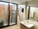 Modern bathroom interior with a glass shower, sink, and wooden accents