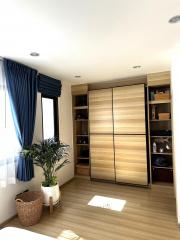 Cozy bedroom with natural light, a large wardrobe, and wooden flooring