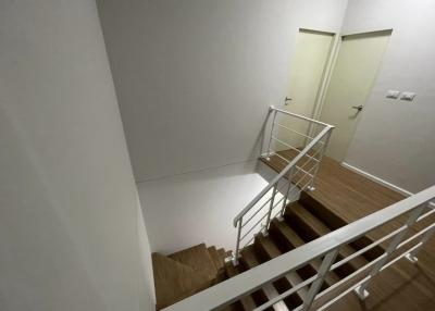 Modern staircase with white walls and metal banisters
