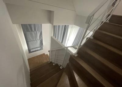 Modern staircase with wooden steps and white walls