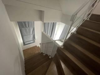 Modern staircase with wooden steps and white walls