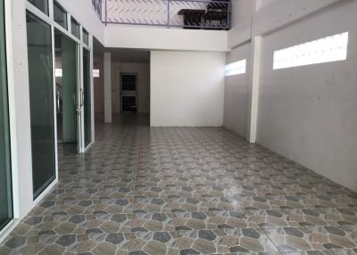 Spacious empty interior of a residential building with tiled flooring and large windows