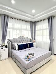 Elegant bedroom with a large, tufted headboard bed, and blue accent decor