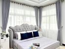 Elegant bedroom with a large, tufted headboard bed, and blue accent decor