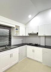 Modern kitchen with marble countertops and white cabinetry