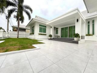 Contemporary white single-story house with a tiled patio and palm trees
