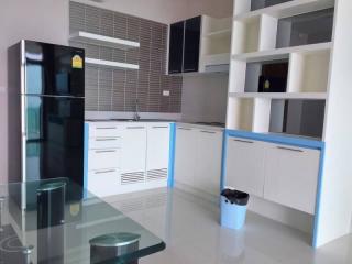 Modern kitchen with white cabinetry and glass dining table