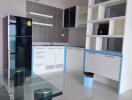 Modern kitchen with white cabinetry and glass dining table