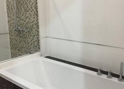 Modern bathroom with a white bathtub and elegant tiling