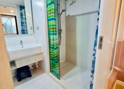 Spacious bathroom with modern glass shower and bright tiled flooring