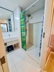 Spacious bathroom with modern glass shower and bright tiled flooring