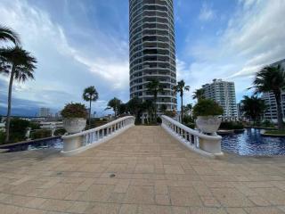 Luxurious high-rise building exterior with a bridge and water feature