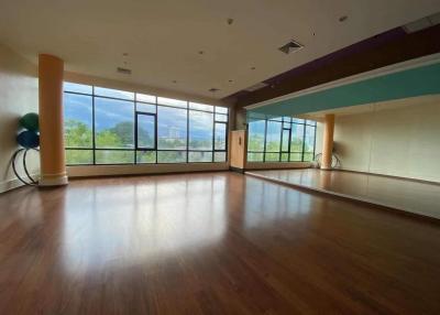 Spacious and well-lit empty room with large windows and wooden flooring