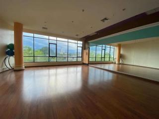 Spacious and well-lit empty room with large windows and wooden flooring