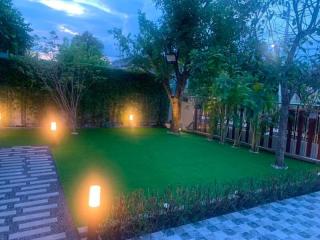 Well-lit backyard garden with lush greenery and pathway lights