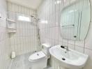 Modern white tiled bathroom with shower, sink, and toilet