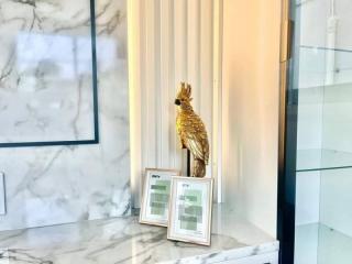 Elegant bathroom interior with marble surfaces and golden bird statue